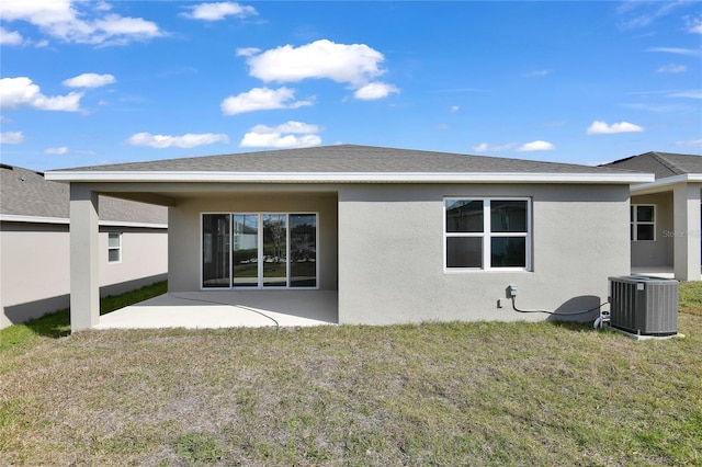 back of property with a lawn, a patio area, and central air condition unit