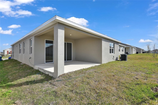 back of property with cooling unit, a yard, and a patio area