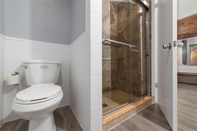 bathroom featuring tile walls, toilet, an enclosed shower, and hardwood / wood-style floors