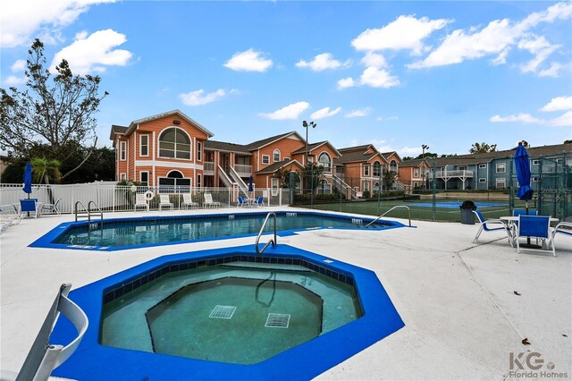 view of pool with a community hot tub and a patio area