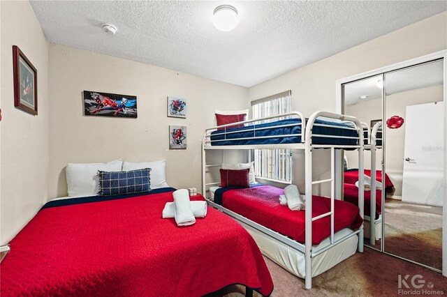 carpeted bedroom featuring a textured ceiling and a closet