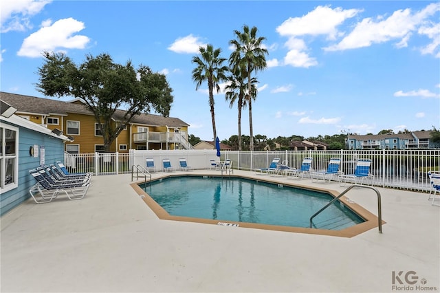 view of pool with a patio and a water view