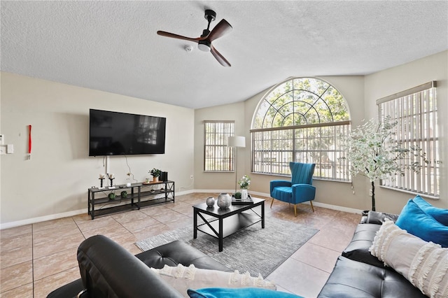 tiled living room featuring ceiling fan, vaulted ceiling, and a textured ceiling