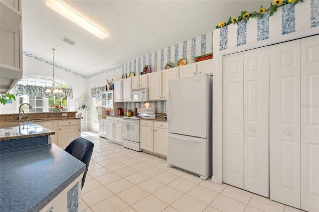 kitchen featuring hanging light fixtures, white appliances, a textured ceiling, light tile patterned floors, and sink