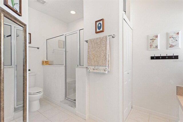 bathroom featuring toilet, tile patterned floors, vanity, and an enclosed shower