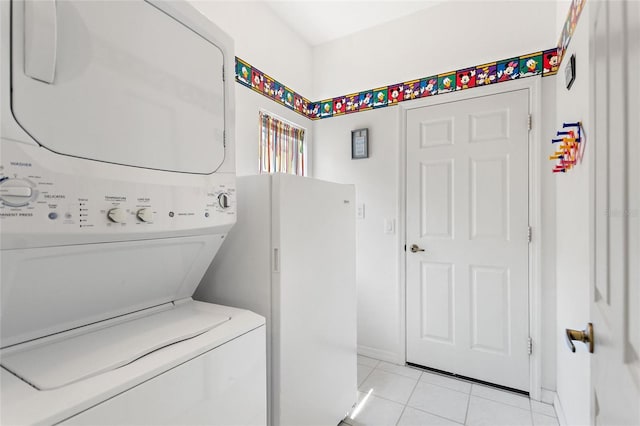 laundry area featuring stacked washer and dryer and light tile patterned flooring