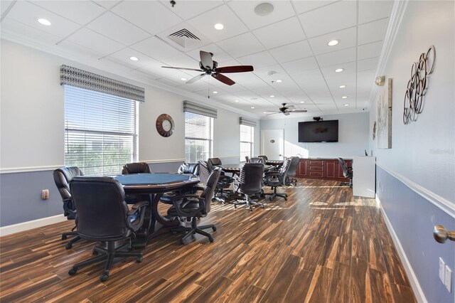 office with ceiling fan, a drop ceiling, dark wood-type flooring, and crown molding