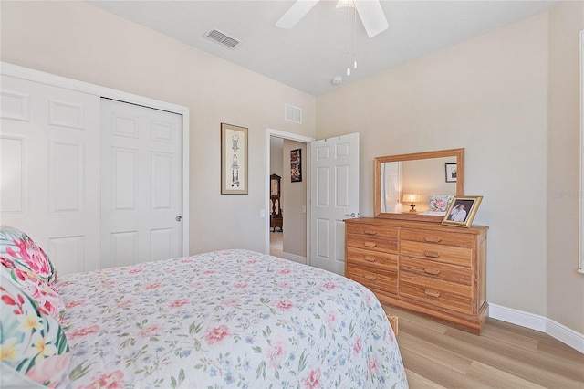 bedroom with baseboards, visible vents, a ceiling fan, light wood-style floors, and a closet