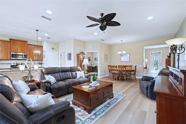 living area featuring light wood-style floors, recessed lighting, and visible vents