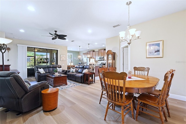 dining space featuring recessed lighting, ceiling fan with notable chandelier, visible vents, baseboards, and light wood finished floors