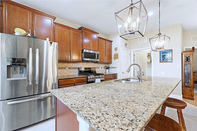 kitchen with a center island with sink, appliances with stainless steel finishes, a breakfast bar, and a sink