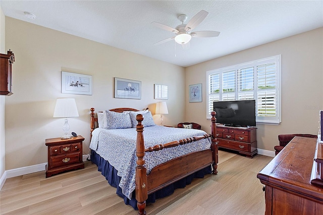 bedroom featuring light wood finished floors, baseboards, and a ceiling fan