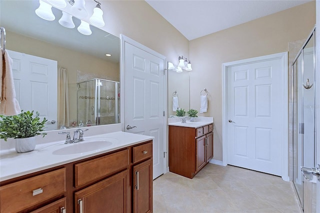 bathroom featuring a stall shower, two vanities, a sink, and tile patterned flooring