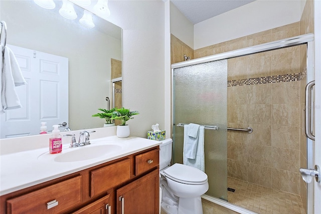 full bath with tiled shower, vanity, and toilet