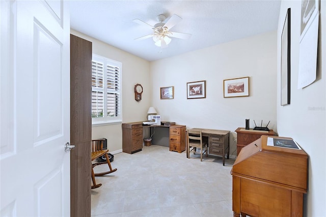 home office with a ceiling fan and baseboards