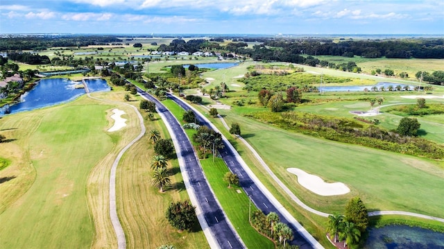 drone / aerial view with a water view and golf course view