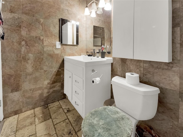 bathroom with toilet, tile walls, and vanity