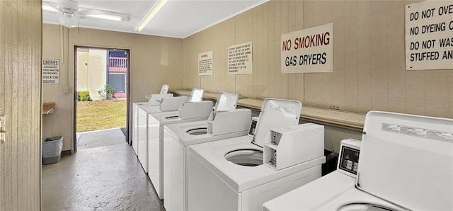 washroom featuring wood walls, ceiling fan, and separate washer and dryer