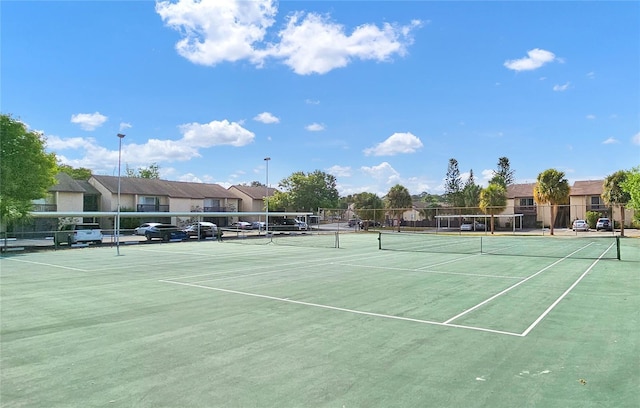 view of sport court with a residential view and fence