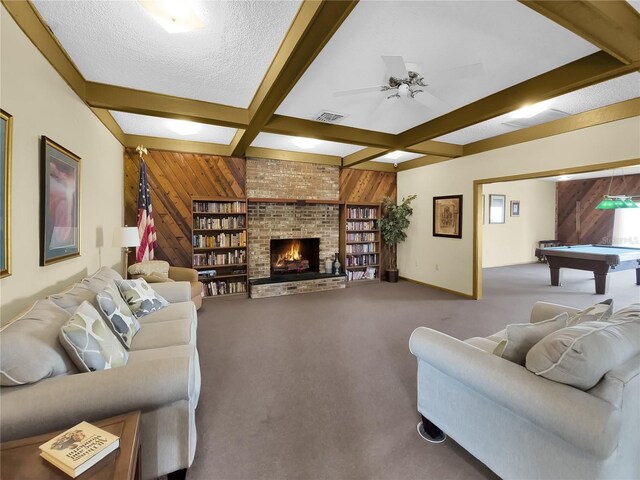 living room featuring carpet, a fireplace, wood walls, beamed ceiling, and pool table