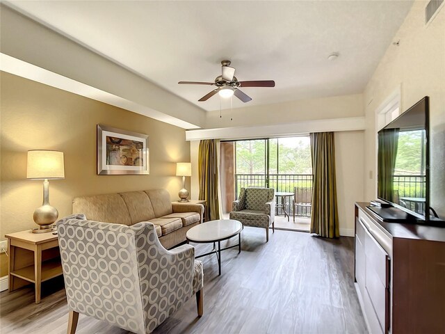 living room with ceiling fan and light hardwood / wood-style flooring