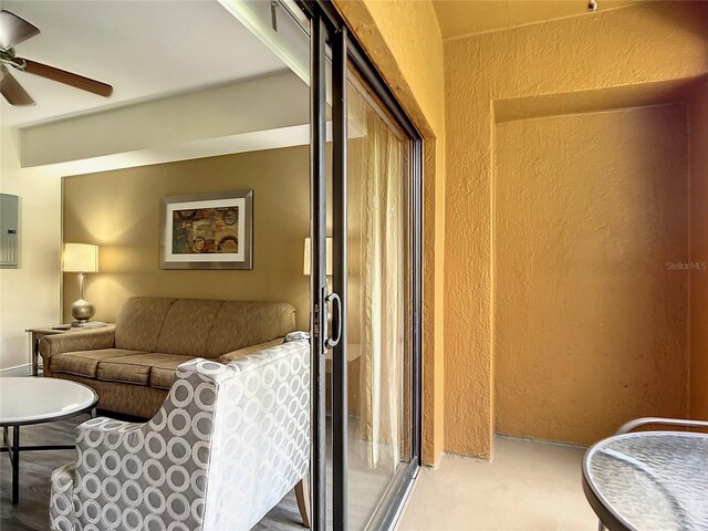 carpeted living room with ceiling fan and electric panel