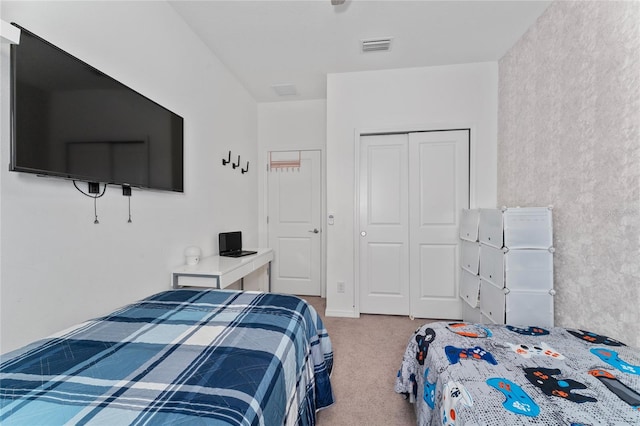 bedroom featuring light colored carpet and a closet