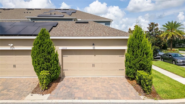 view of front facade with a garage and solar panels