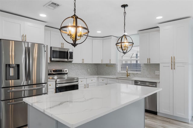 kitchen with visible vents, stainless steel appliances, an inviting chandelier, and a sink