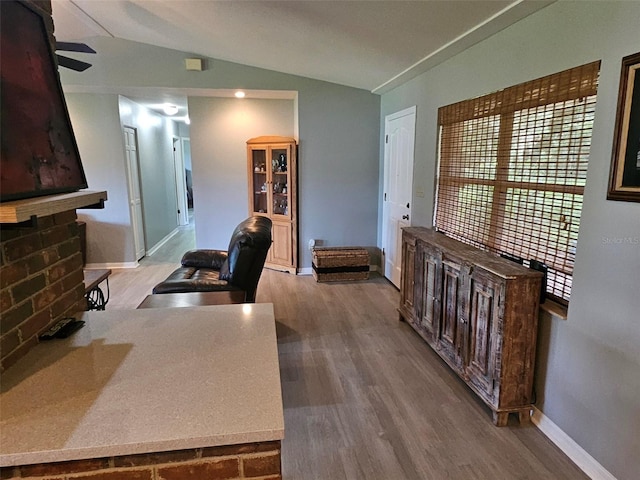 office area featuring ceiling fan, hardwood / wood-style floors, and vaulted ceiling