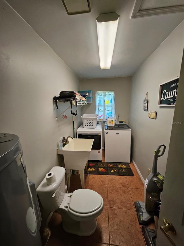 bathroom with washer and dryer, tile patterned flooring, and toilet