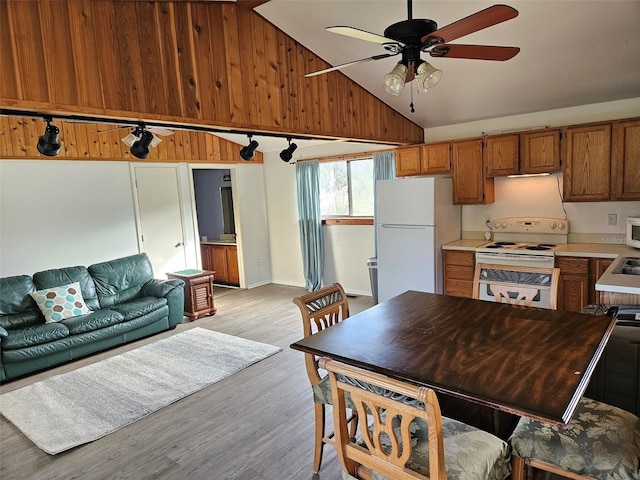 kitchen featuring lofted ceiling, light hardwood / wood-style floors, white appliances, and ceiling fan