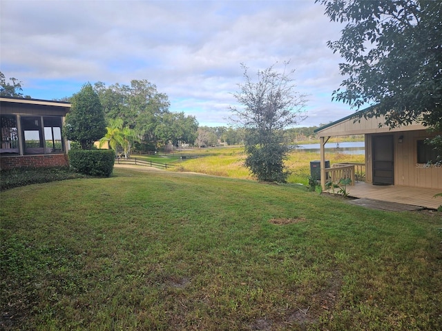 view of yard with a water view and a sunroom