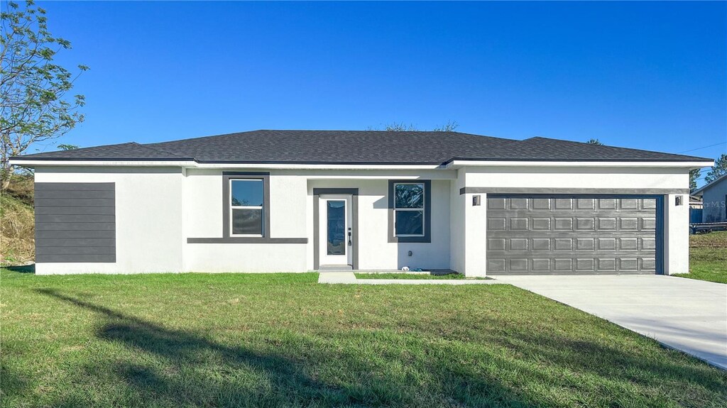 ranch-style house featuring a garage and a front lawn