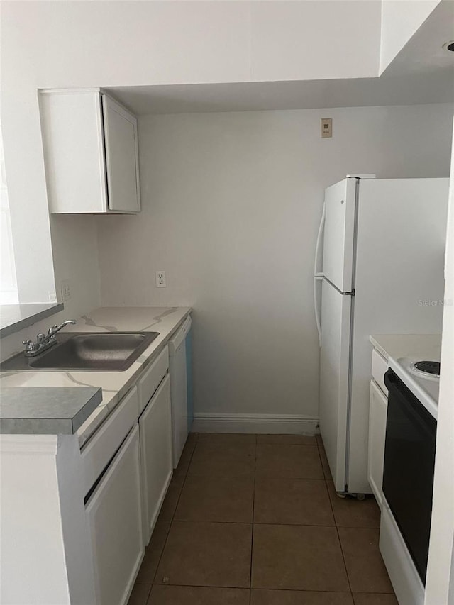 kitchen with white cabinetry, sink, white appliances, and dark tile patterned floors