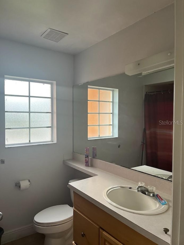 bathroom featuring vanity, plenty of natural light, and toilet