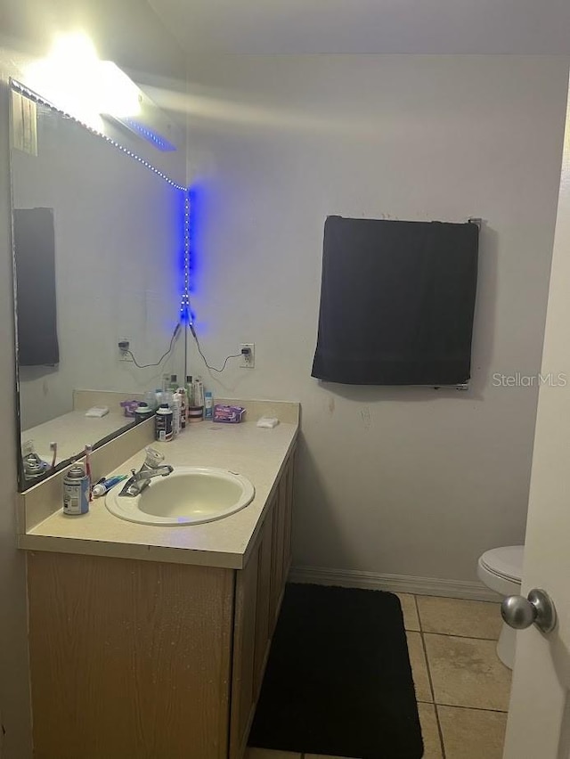 bathroom with toilet, vanity, and tile patterned floors