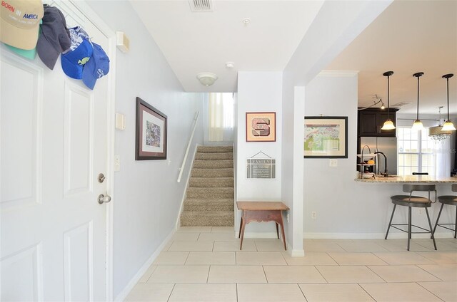 stairs featuring baseboards, visible vents, and tile patterned flooring