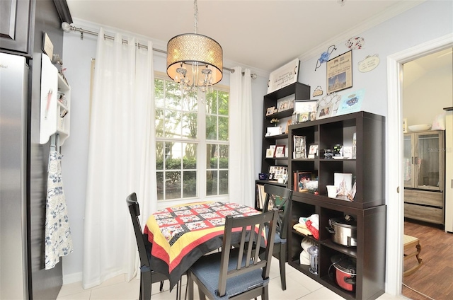 dining space featuring ornamental molding, a notable chandelier, and light wood finished floors