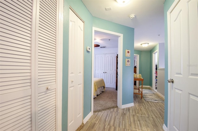 hall with light wood finished floors and baseboards