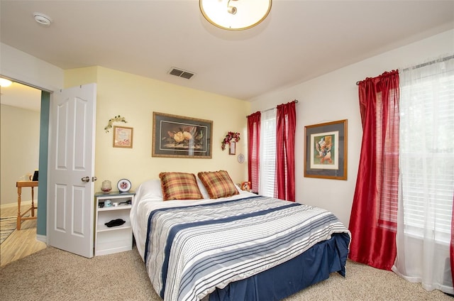 bedroom with visible vents and light colored carpet