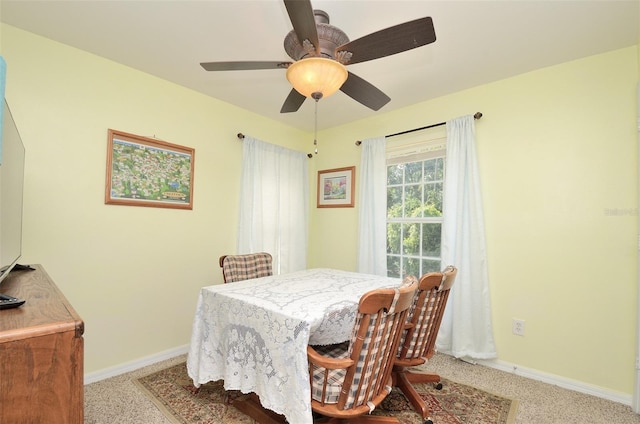 dining room with light carpet, ceiling fan, and baseboards