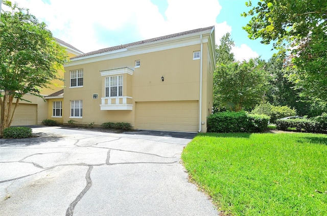 view of front of home featuring driveway, an attached garage, and stucco siding