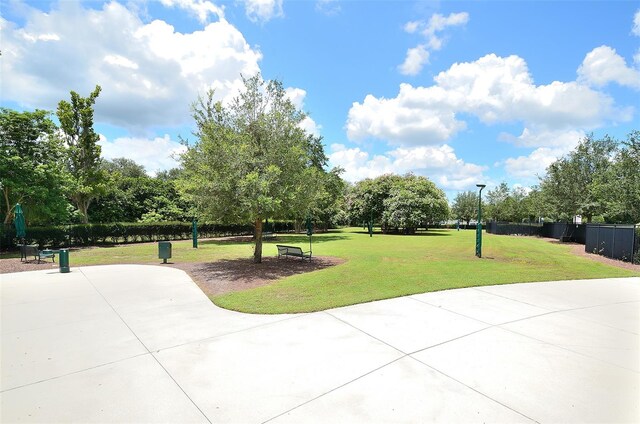 view of home's community featuring a lawn and fence