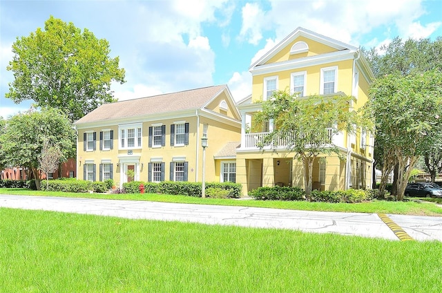 view of front of house with a balcony and a front yard