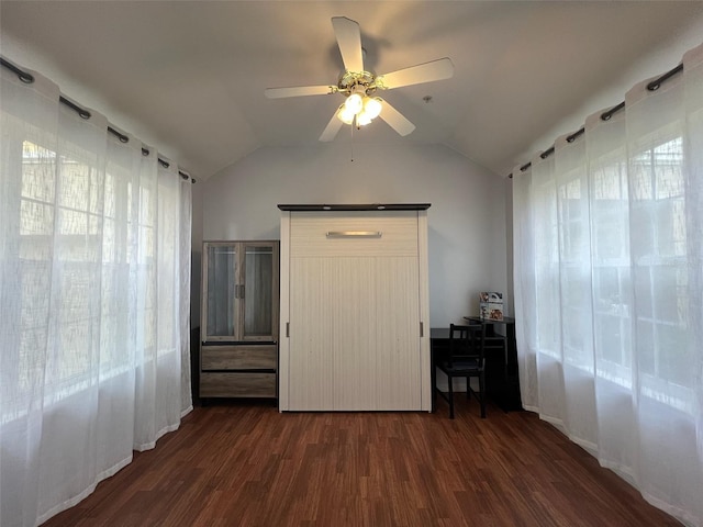 unfurnished bedroom featuring lofted ceiling, a ceiling fan, and dark wood-type flooring