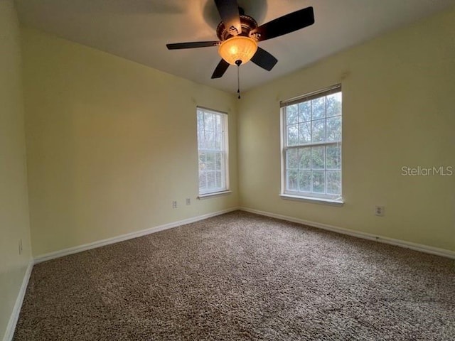 spare room featuring carpet and baseboards