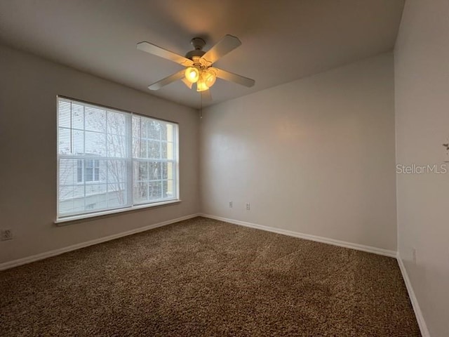 spare room with carpet floors, ceiling fan, and baseboards