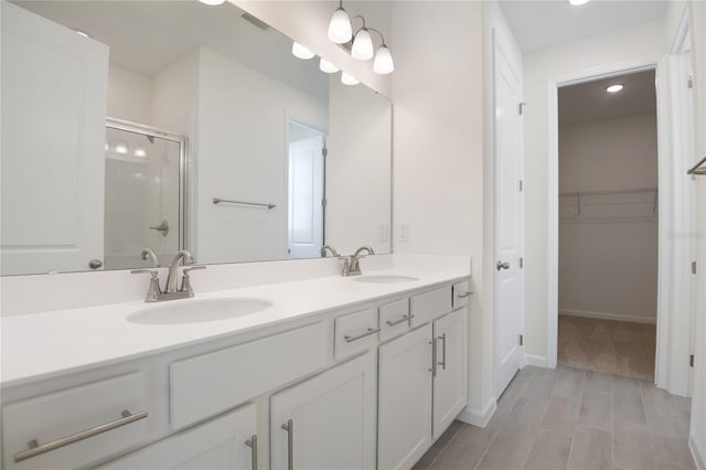 bathroom featuring vanity and a shower with shower door