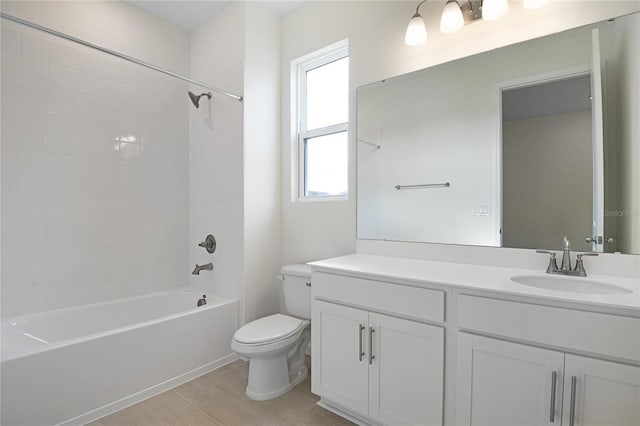 full bathroom featuring vanity, tiled shower / bath combo, and toilet